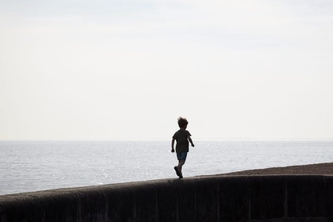 Boy running along a wall