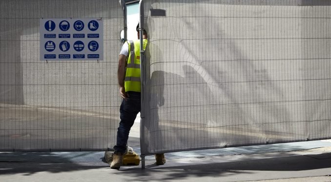 Builder by a fence