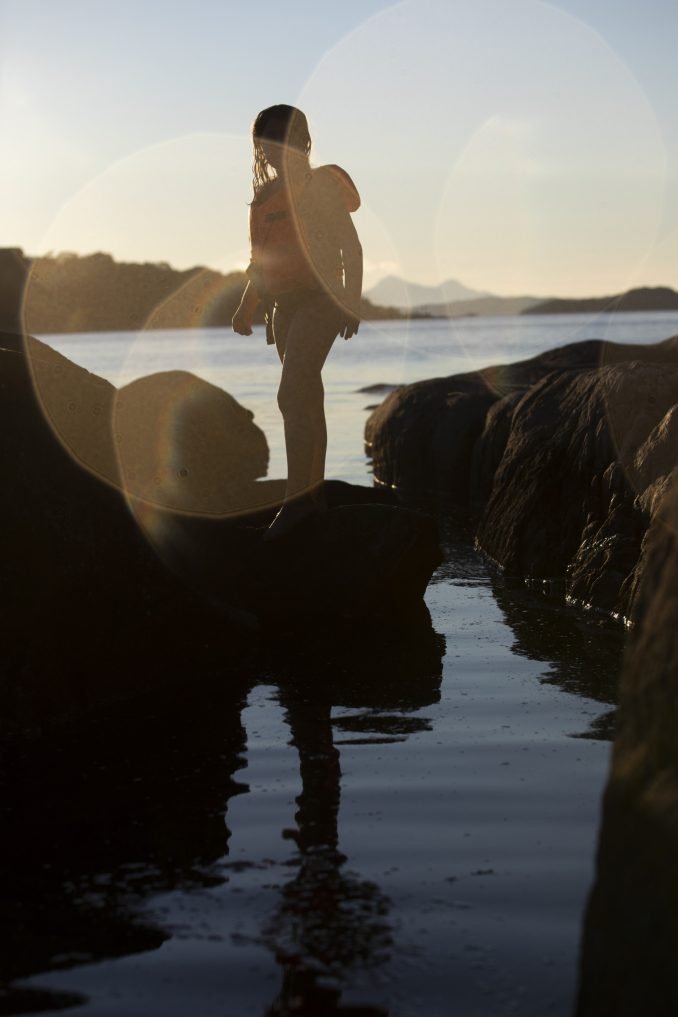 Girl at sunset on beach by water